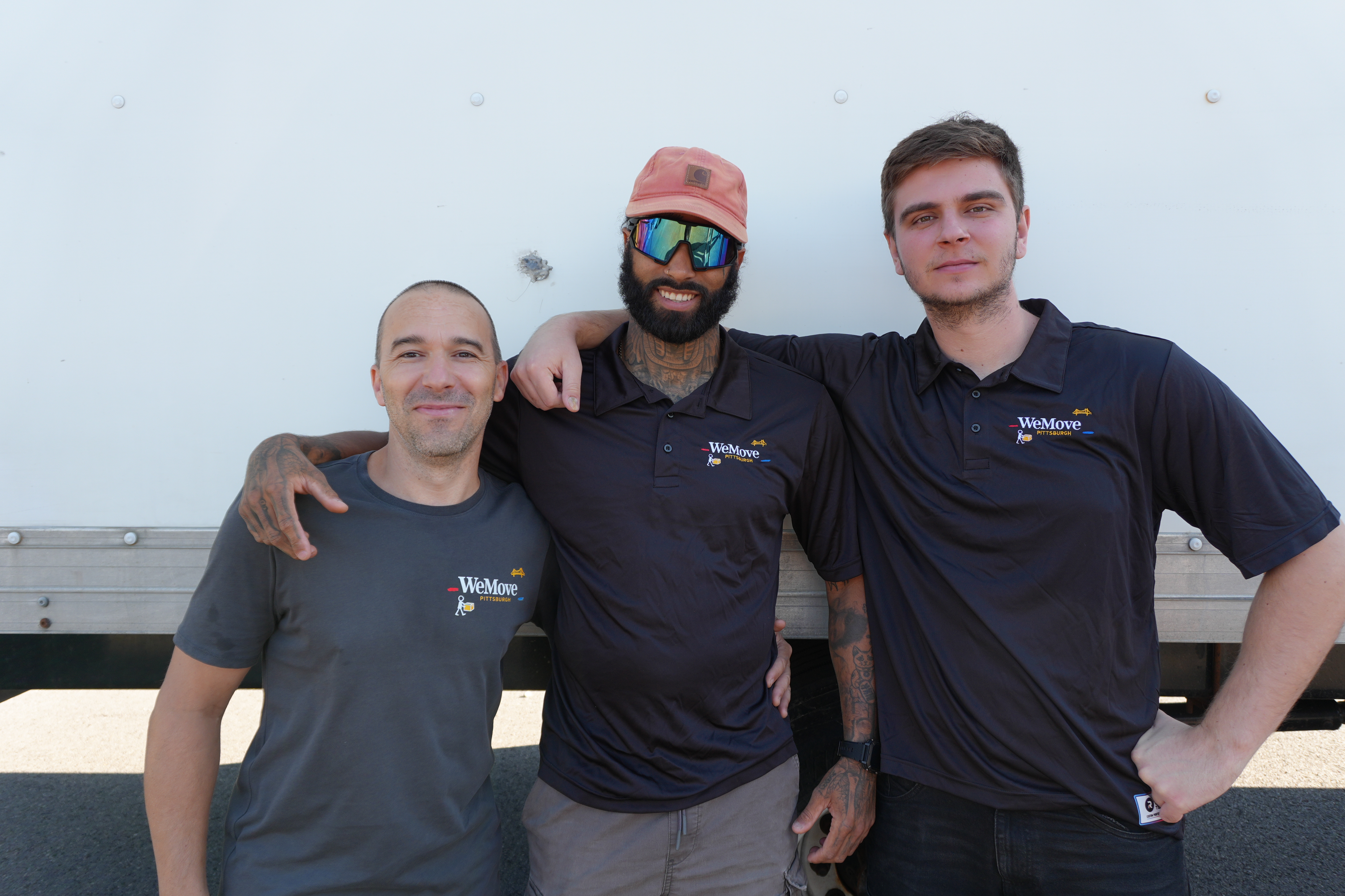 Three WeMove Pittsburgh movers posing together by the truck